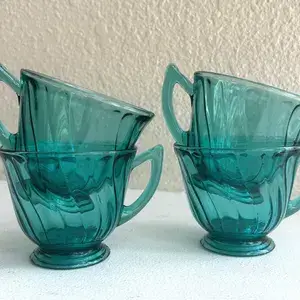 The Elysian Tumbler, a glass with a swirling teal pattern.